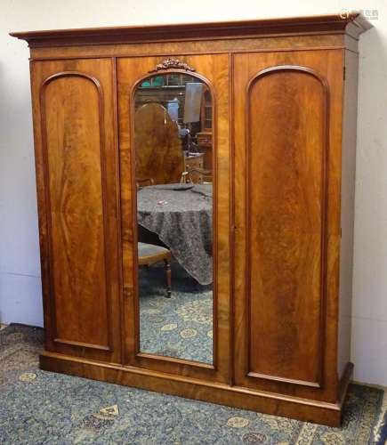A 19thC mahogany triple wardrobe with a moulded cornice abov...