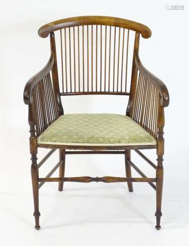 An early 20thC elbow chair with a shaped top rail above a sp...
