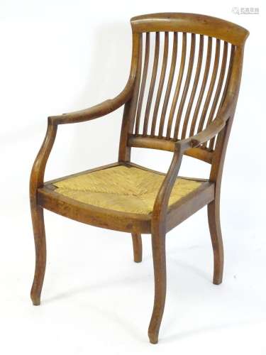 An early 20thC open armchair with a curved top rail above a ...