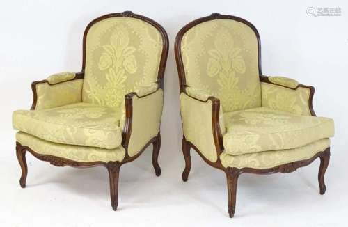 A pair of late 20thC fauteuil armchairs with floral carved f...