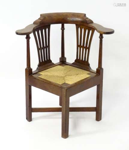 An 18thC mahogany corner chair with scrolled arms above turn...