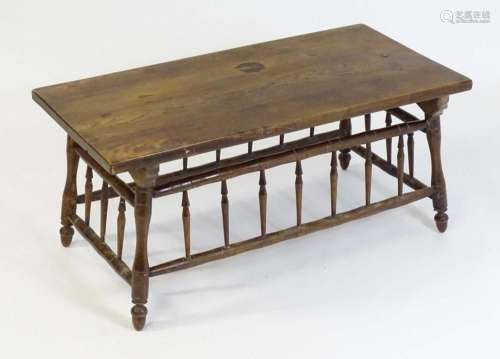 An Arts and Crafts style low table with an elm top above fou...