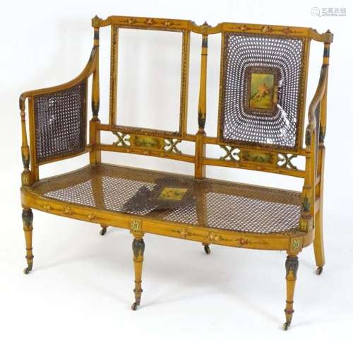 An early 20thC satinwood bergere settee with a watercolour p...