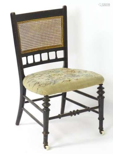 A 19thC ebonised side chair / nursing chair with a caned bac...