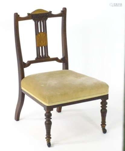 An Edwardian nursing chair with a mahogany frame and satinwo...