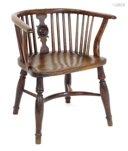 An early 19thC yew Windsor chair with a bowed back and a dra...