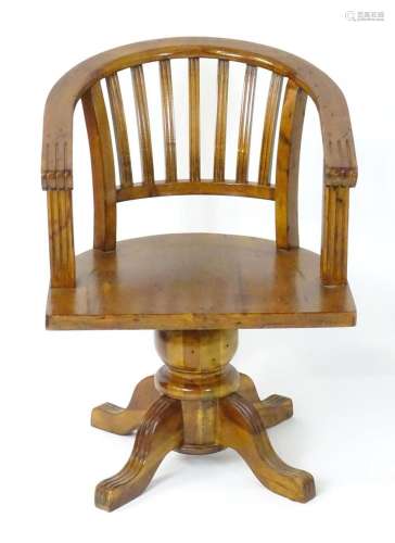 A late 20thC captains chair with a bowed back and slatted ba...