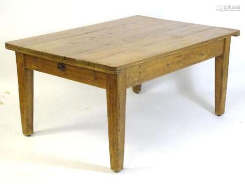 A 19thC pine farmhouse kitchen table, having a planked top a...