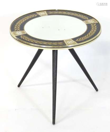 A mid century tripod table with a mirrored centre and wreath...