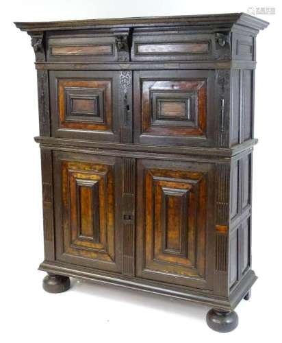 A 17thC oak livery cupboard with a moulded cornice above car...