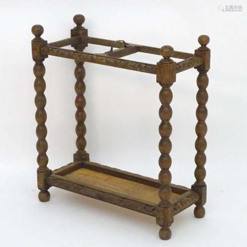 An early 20thC carved oak umbrella / stick stand with four b...