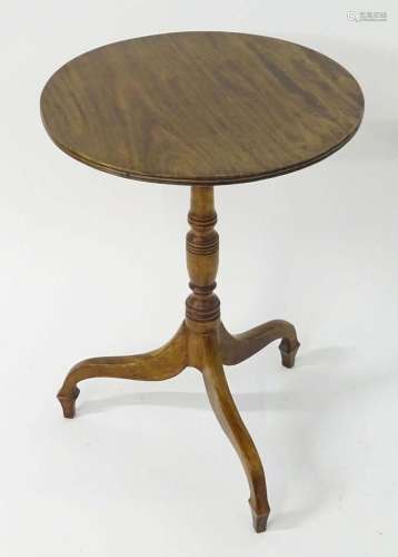 A mahogany 19thC tripod table with a circular reeded top abo...