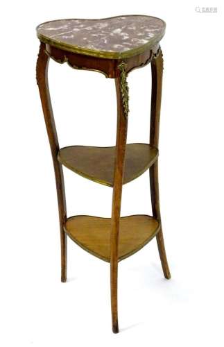 An early 20thC three tier mahogany stand with a marble top a...