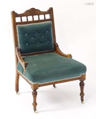 A late 19thC nursing chair with a carved cresting rail above...