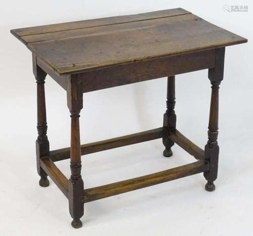 An 18thC oak table with a planked top above a peg jointed ba...