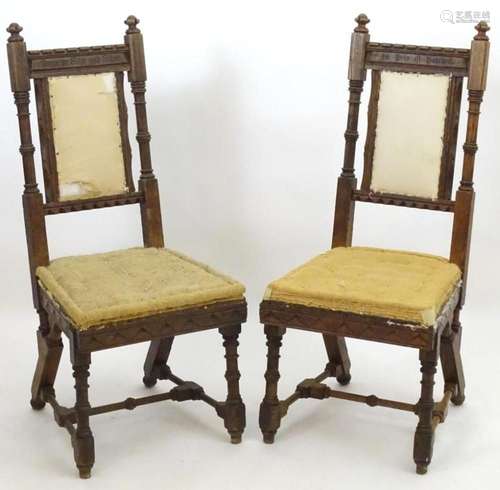 A pair of 19thC oak Gothic chairs, mounted by carved finials...