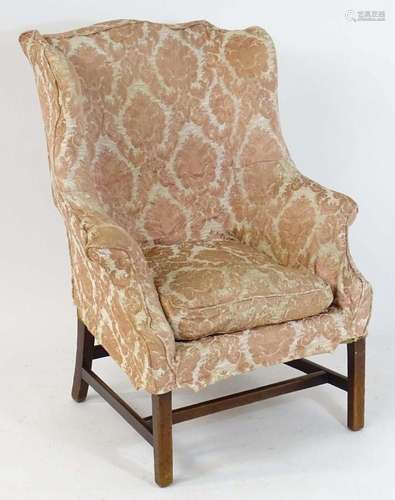 An 18thC wingback armchair with a shaped backrest, scrolled ...