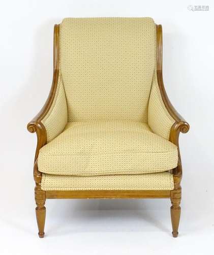 A Wesley Barrel armchair with a scrolled backrest, frame and...