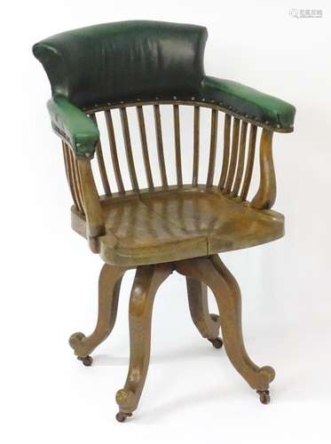 An early 20thC oak captains chair / desk chair, having leath...