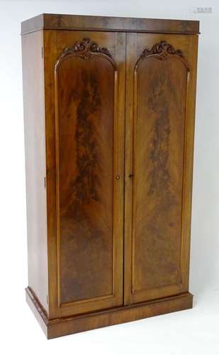 A mid 19thC mahogany double wardrobe with two panelled doors...