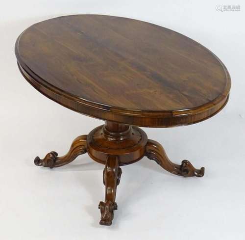 A mid 19thC rosewood tilt top table, having an oval table to...