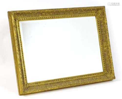 A mid 20thC giltwood and gesso mirror with a moulded frame, ...