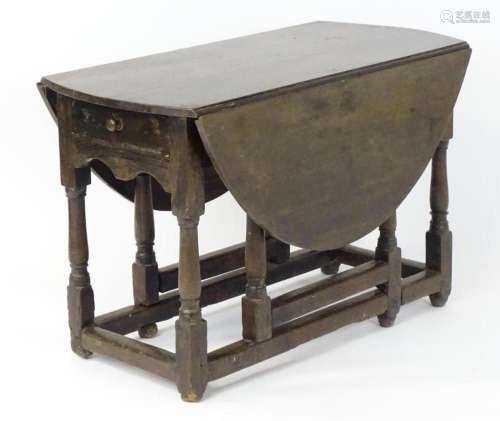 A 17thC oak drop leaf table, having demi lune leaves to each...