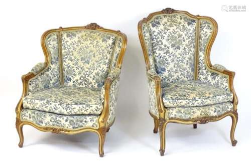 A pair of mid / late 20thC his and hers armchairs, having ca...