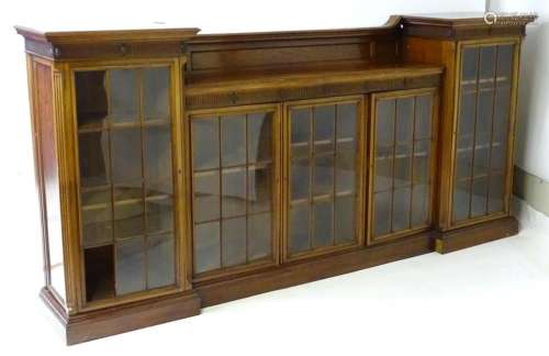 An early 20thC mahogany breakfront bookcase with moulded cor...