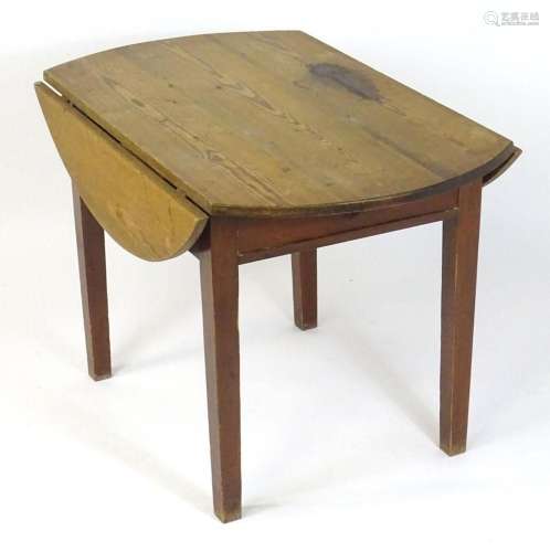 An early 20thC pine farmhouse table with two drop leaves abo...