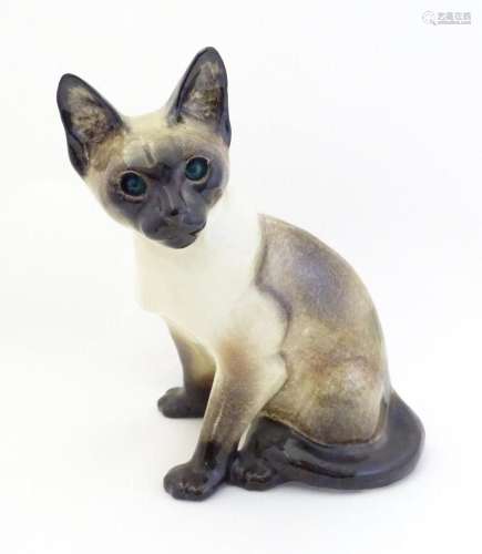 A large Winstanley model of a seated Siamese cat with blue e...