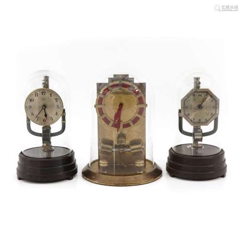 A Collection of 3 Electric Clocks under Glass Domes