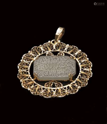 A GOLD MOUNTED TALISAMIC CARVED JADE PENDANT