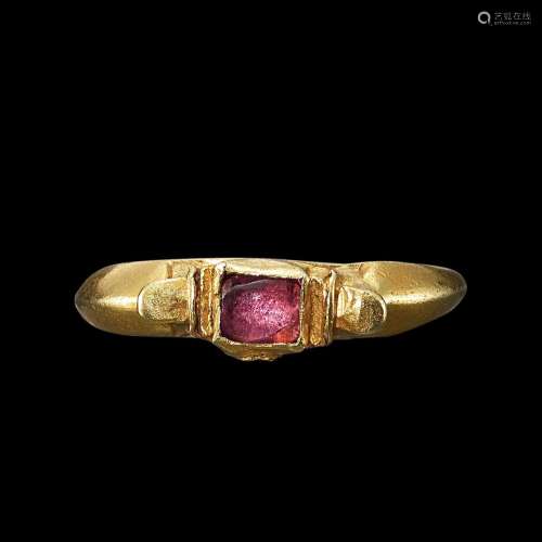 . A solid gold and pink sapphire ring with oval shoulders Ja...