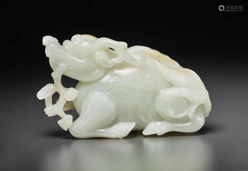 A VERY FINELY CARVED WHITE JADE FIGURE OF A RECUMBENT MYTHIC...