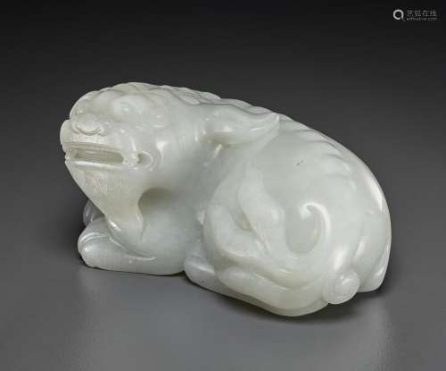 A FINELY CARVED PALE GREYISH-WHITE JADE FIGURE OF A RECUMBEN...