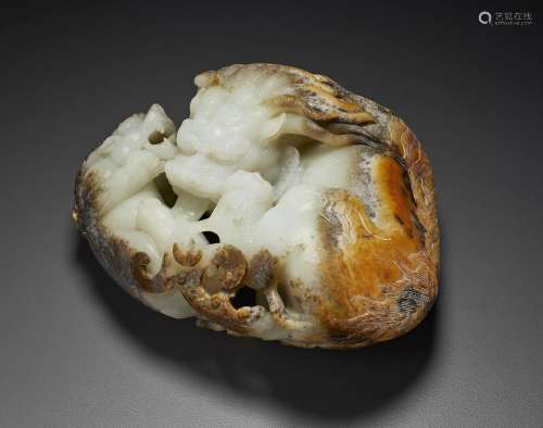 A WHITE, BLACK AND RUSSET JADE CARVING OF A MYTHICAL BEAST A...