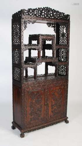 A Chinese carved darkwood display cabinet, Qing Dynasty, the...