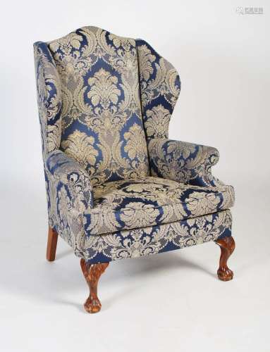 An early 20th century upholstered wingback armchair in the G...
