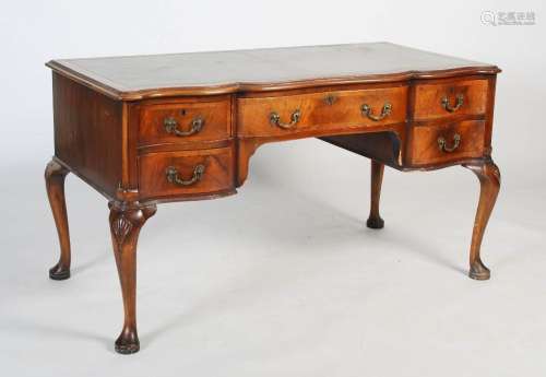 A Queen Anne style walnut desk, the serpentine top with step...