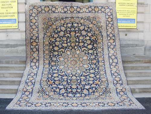 A 20th century Persian Kashan carpet, the indigo field with ...