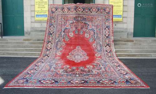 A very large antique Persian carpet, the deep red plain fiel...