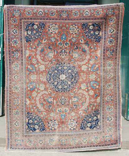 An antique Persian carpet, the madder field with palmettes a...