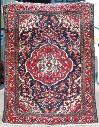 An early 20th century Persian carpet, the indigo field with ...
