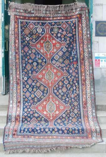 An antique Persian carpet, the indigo field with rich patter...