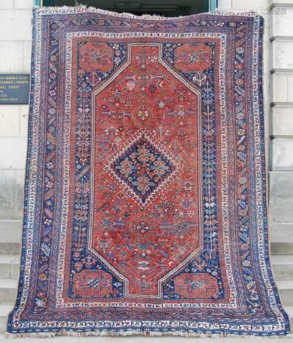 An antique Persian carpet, the deep red field with rich desi...