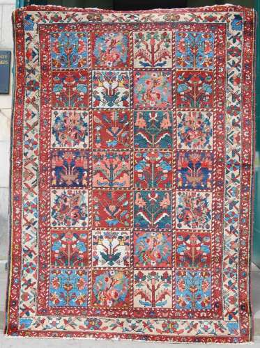 A 20th century Persian carpet, the deep red, green, indigo a...