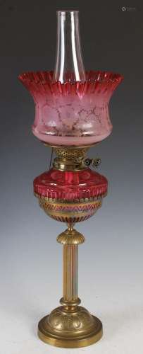 A Victorian brass oil lamp, with facet cranberry glass reser...