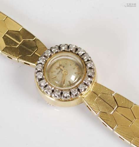 A lady`s 18ct gold Omega watch with diamond set bezel, the c...