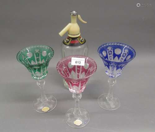 Three large overlaid coloured glass goblets, together with a...